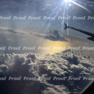 View of clouds, sunlight, airplane wing, and Atlantic Ocean from a plane window, used as Anatomy of Release chapter art